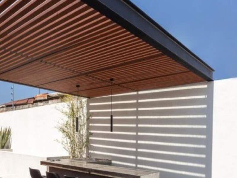 Pérgola en PVC entre muros textura madera